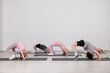 © New Africa - Group of children practicing yoga on mats in class