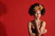 © New Africa - Fashionable portrait of beautiful Brazilian woman in stylish outfit on red background. Space for text