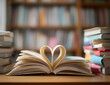 © Daniel - Love story book with open page of literature in heart shape and stack piles of textbooks on reading desk in library study room for national library lovers month and education learning concept