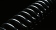 © Dollar - Black Metal Spring Coil Close Up on Dark Background