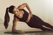 © New Africa - Sporty woman doing side plank exercise on fitness mat indoors