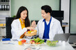 © laddawan - Doctors sharing fresh vegetables, promoting health and nutrition. Ideal for wellness, healthcare, and science themes.