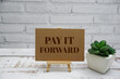 © may1985 - Pay It Forward text message with easel stand on wooden background