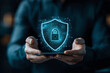 © Tondone - Businessman holds smartphone displaying digital shield symbolizing cybersecurity and protection. image conveys sense of security and innovation in technology