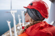 © Olha Havelia - Close up, Female engineer standing on top of a wind turbine