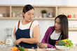 © wichayada - Cooking Together: Two Women Preparing Healthy Meals in Modern Kitchen