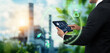 © panuwat - Sustainable Technology for Industry Smart Solutions for Environmental Management concept, business man using digital tablet on blurred green industry as background