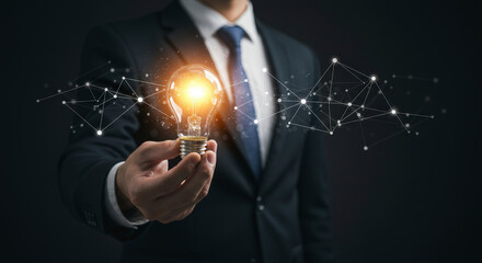 Wall Mural - Illuminated Light Bulb Held by Businessman in Dark Suit Depicting Innovative Ideas with Futuristic Neural Network on Black Background