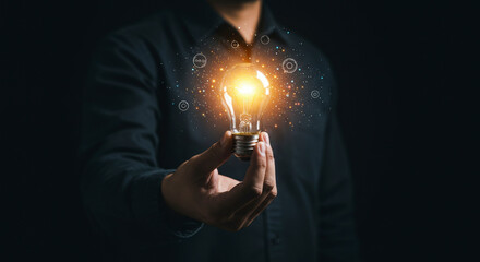 Wall Mural - Man Holding Glowing Lightbulb Idea Generation and Conceptualizing a Bright Idea in Dark Theme Representing Invention and Innovation