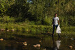 © Wavebreak Media - African American man cleaning stream in gloves, boots collecting litter into trash bag, copy space