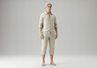 © PTC - A man stands barefoot in a neutral linen outfit against a plain background, looking directly at the viewer.