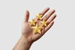 © MAJIDULISLAM - Human hand holding four golden stars symbolizing achievement success and excellent customer service rating