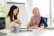 © Fahng - Arabian muslim islamic woman in hijab female investor employer signing contract document conclude business deal agreement partnership businesswoman and client cooperation multiracial women in office.