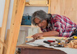 © Rakchanok - Senior people retirement lifestyles concept, Asian elderly carpenter using planer in carpentry studio shop create own small business, old aging man with silver hair working  DIY wooden cup of coffee
