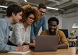 © Ozz - A diverse team collaborates on a laptop in the office, working together on a project.