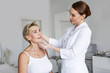 © Anna Zhukkova - Cosmetologist in white coat examining mature woman's face on professional anti-aging consultation in aesthetic clinic, checking skin before rejuvenation treatment, beauty and skincare in medical spa