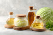 © Andsx - Glass Bottles of Oil and Fermented Cabbage on Wooden Coasters