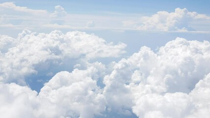 Wall Mural - Aerial view of puffy white cloud over clear blue sky while flying in airplane, Airplane flight flying above the clouds. View from the window of the plane traveling by air, natural background concept