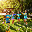 © md - Four happy children play with water guns in a sunny backyard, enjoying a summer day filled with laughter and fun