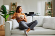 © djile - Young athletic woman eating healthy breakfast at home sitting on sofa