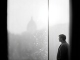 A Man's Contemplative Moment: Lost in Thought by a City Window on a Foggy Day. A Black and White Masterpiece of Solitude and Reflection
