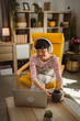 © Miljan Živković - Japanese woman work on laptop computer at home wear headphones watch movie online or browse internet