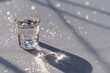 © Oleksandr - minimalist photograph of crystal clear cup filled with sea water placed on light gray background