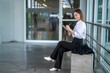 © Wasana - Businesswoman working remotely sitting on bench writing on clipboard