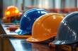 © Milana - Row of various colored construction helmets neatly arranged on a wooden surface in a workshop setting, conveying preparedness and safety