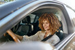 © SHOTPRIME STUDIO - Smiling woman with curly hair driving a modern car, wearing a beige blouse, enjoying a sunny day and safety with seatbelt fastened, casual lifestyle.