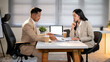 © bongkarn - Businessman and woman or office worker looking at the documents on working table during a meeting.