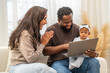 © Art_Photo - African love family happy time at home, father showing baby a tablet with cartoons for early childhood learning and development, mother smiling engaging in digital parenting and interactive education