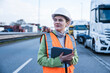 © Westend61 - Woman in safety gear managing logistics outdoors with tablet