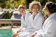 © Rido - Women friends laughing at poolside at luxury resort