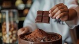 Celebrating world chocolate day with delicious treats and rich cocoa beauty. Horizontal banner. Copy space. Free space for text. Piece of chocolate in hands of pastry chef