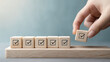 © Rohan Katwe - hand places a wooden block with a checkmark, completing a row of similar blocks.  It symbolizes task completion, goal achievement, or project success.  sense of accomplishment and progress.