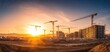 © Bohdana - The construction site illuminated by a stunning sunset panorama over cranes.