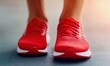 © Yevheniiya - Close-up shot of red sneakers on a person. The shoes are new, vibrant, and ready for exercise or a run, with a focus on fitness and style.