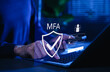 © Supatman - MFA, Multi-Factor Authentication Security Concept. Person typing on laptop with MFA shield icon and login interface, representing multi factor authentication, secure login, cybersecurity protection.