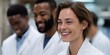 © Iryna - Young caucasian female scientist smiling in laboratory with diverse colleagues in background