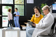 © DC Studio - General practitioner assisting woman with cervical neck brace at hospital lobby, doing a routine checkup. Medical care staff explaining neck trauma recovery steps and medication options.