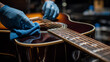 © Narmin - Technician carefully wipes down an acoustic guitar fretboard during routine instrument maintenance.