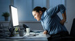 © SteffCunha - Woman office worker with back pain from sitting at desk all day computer work ergonomics posture health problem