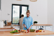 © SHOTPRIME STUDIO - middle age woman preparing healthy food in kitchen with fresh vegetables, promoting active and healthy lifestyle, wellbeing, and fitness indoors