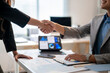 © Apichat - A man shakes hands with a woman in a business setting