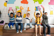 © Alan - Diverse group of preschool children holding large colorful letters spelling “English” in a bright classroom. Early language learning, playful literacy, preschool and kindergarten education