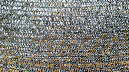Detailed full-frame close-up of a silver-colored woven net, possibly a shade net or agricultural net.