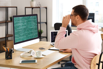 Wall Mural - portrait of focused male programmer working in office