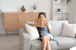 © Pixel-Shot - Little schoolgirl reading book on sofa at home