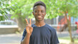 © stockbakers - Casual African Man Showing Peace Sign Outdoors